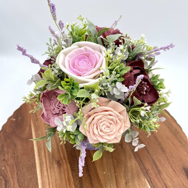 Purple and pink wood flowers with greenery, baby's breath and lavender accents in a coordinating metal bucket