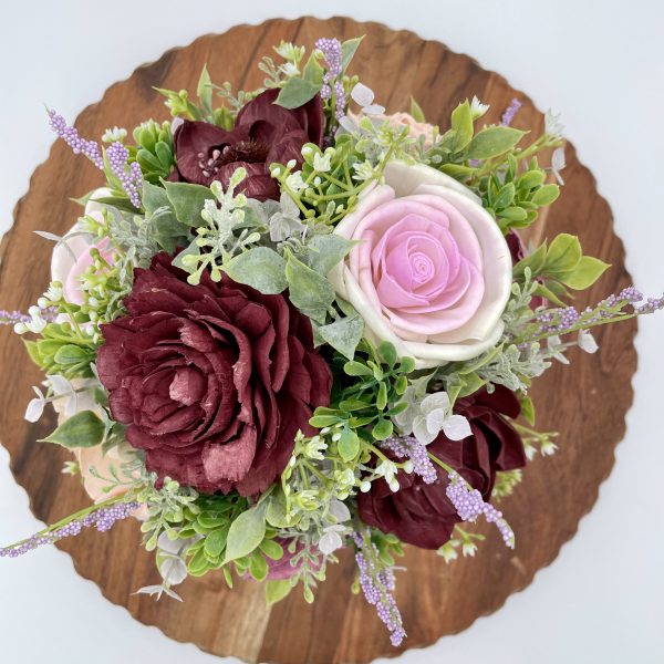 Purple and pink wood flowers with greenery, baby's breath and lavender accents in a coordinating metal bucket
